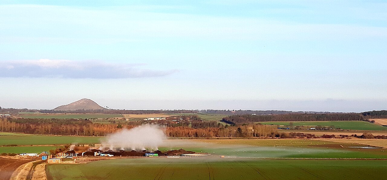 Steam rising off commercial compost heaps on a cold morning