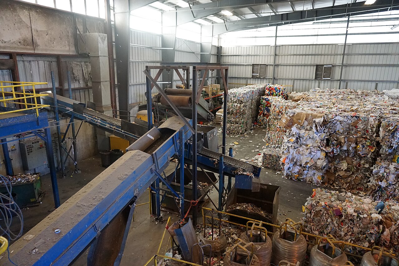 Conveyors and stacked bales of recovered paper inside a materials recovery facility