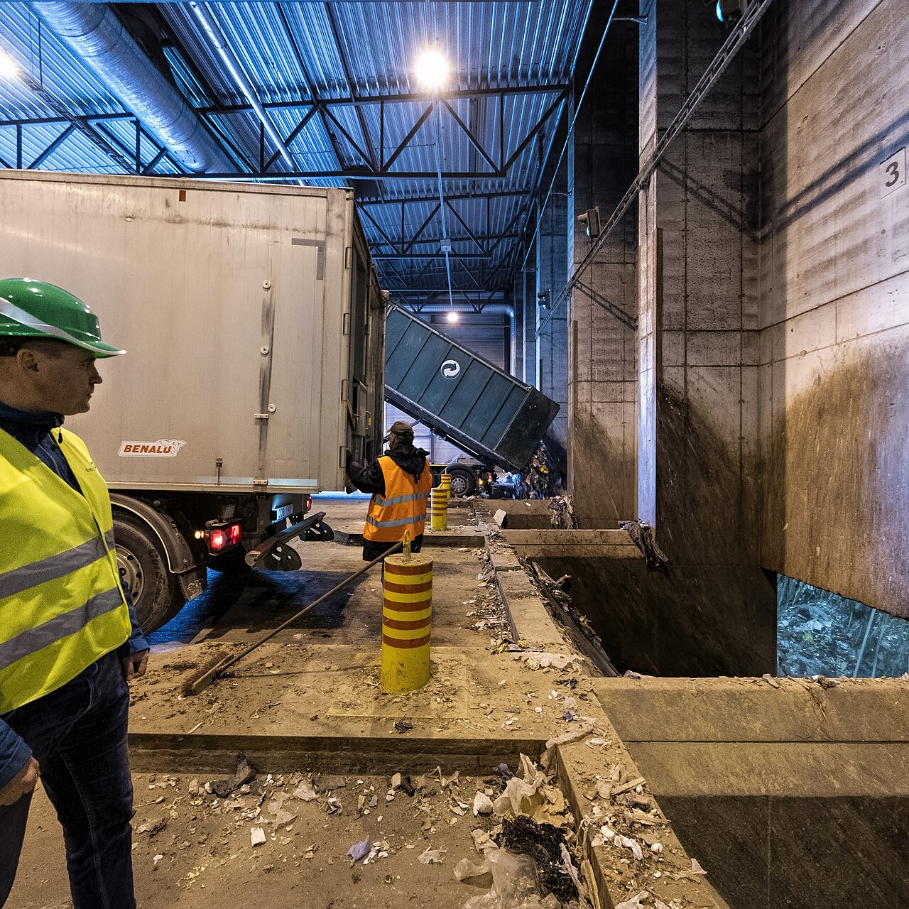 A lorry tips a full container of mixed waste into the receiving bunker of a recovery facility